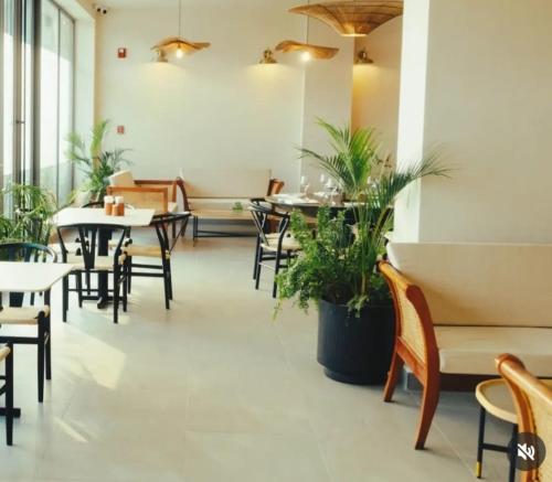 アクラにあるThe Haven-Loxwood Luxury 2-Bed with Rooftop Poolのテーブルと椅子と植物のあるレストラン