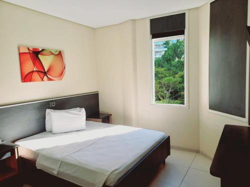 a bedroom with a bed and a window at Flat - Apartium Palacete Victória in Sao Paulo