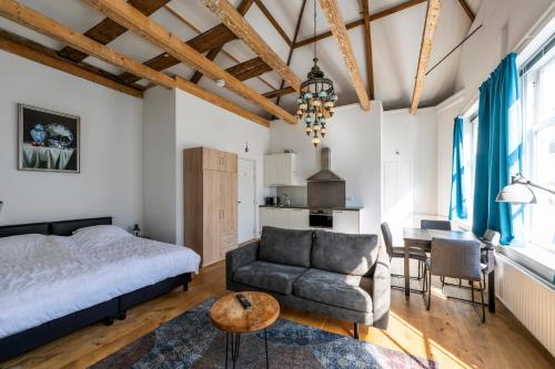 a bedroom with a bed and a couch and a table at Barbera Guesthouse Hotel Apartments - Experience local life in the Old Centre in Haarlem