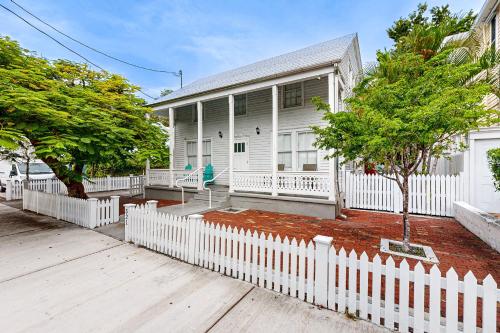 a white picket fence in front of a white house at Gardenia Getaway in Key West