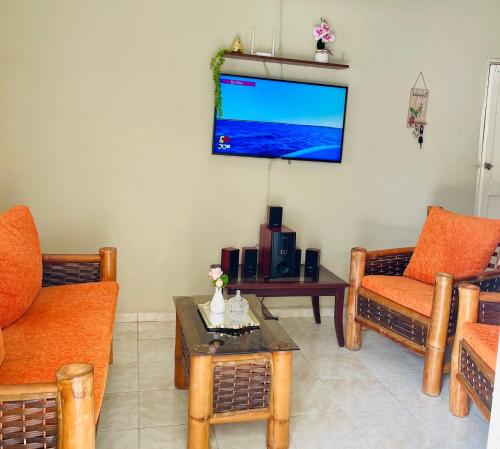 a living room with a flat screen tv on the wall at Hospedaje Fdez Bta En Pedernales in Pedernales
