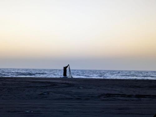 a person standing on a beach near the ocean at Shtepia Druri Sokol Lulaj in Lezhë