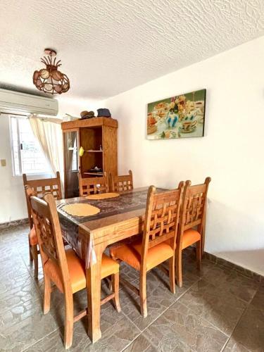 a dining room with a wooden table and chairs at Casa en Ixtapa in Ixtapa
