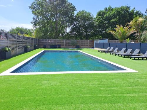 a swimming pool in a yard with chairs and grass at Chalet Lot 23 - 4-6 places in Herm