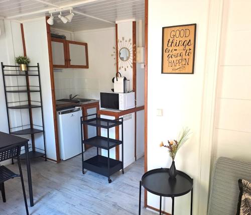 a room with a table and chairs and a kitchen at Chalet Lot 23 - 4-6 places in Herm