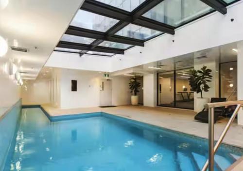 a large swimming pool in a building with a ceiling at Panoramic City View High-Rise 2BR & Skytower-Adj in Auckland