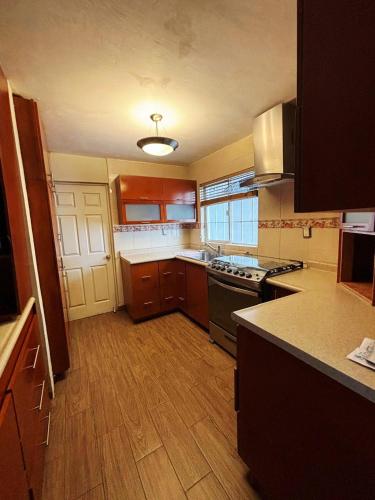 a kitchen with wooden floors and a stove top oven at Habitacion Olmo in Saltillo