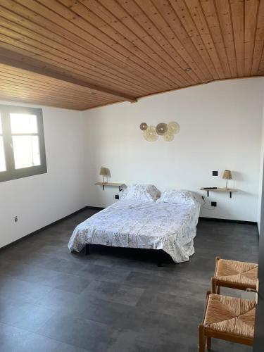 Appartement في لا ترانش سور مير: غرفة نوم بها سرير وسقف خشبي