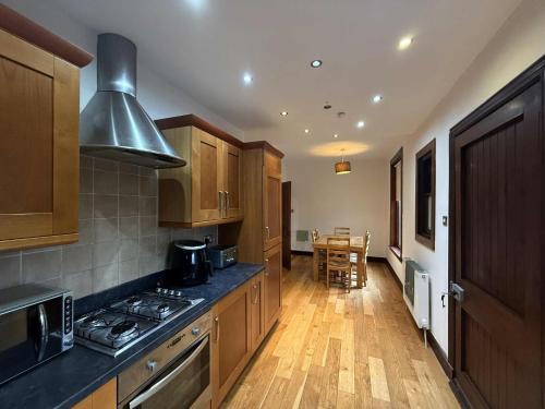 a kitchen with wooden cabinets and a stove top oven at The Orchard Hotel in Falkirk