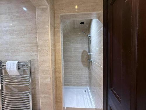 a shower with a glass door in a bathroom at The Orchard Hotel in Falkirk