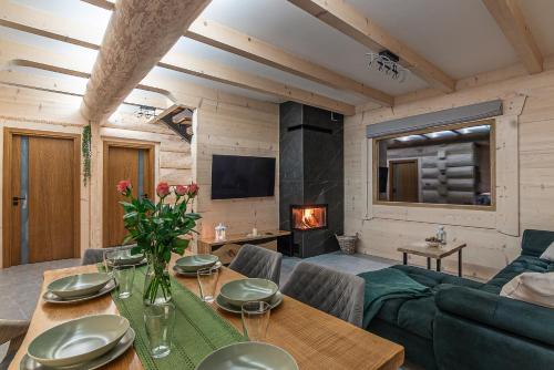 a living room with a table and a fireplace at Zielone Wzgórze in Sidzina