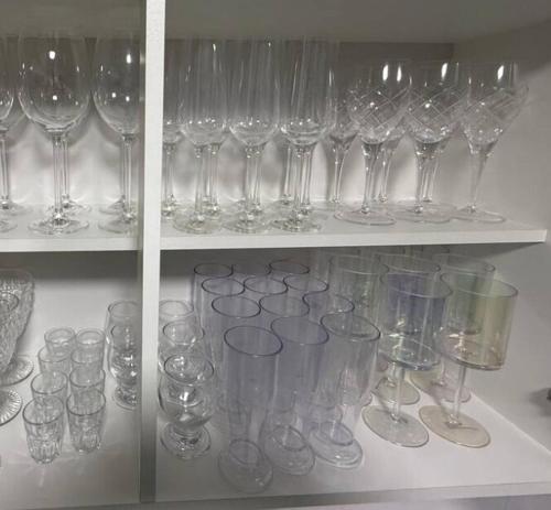 a bunch of wine glasses sitting on a shelf at Luxury, Charm and Comfort in Guaratuba in Guaratuba