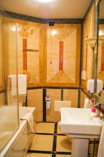 a bathroom with a sink and a toilet and a tub at Villa Masseria Marini in San Giuseppe Vesuviano
