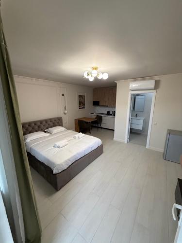 a bedroom with a large bed and a kitchen at Golden Sky Residence in Satu Mare