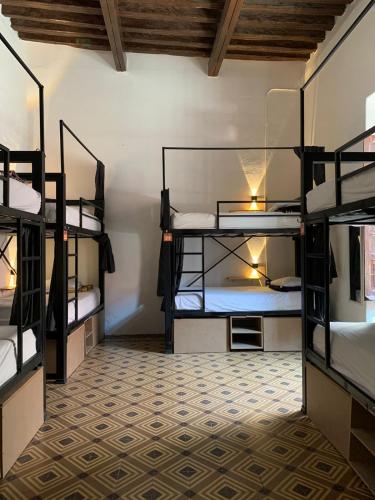 a room with four bunk beds in a building at Sukha Hostel San Luis in San Luis Potosí