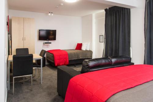a hotel room with two beds and a television at 538 Great King Motel in Dunedin