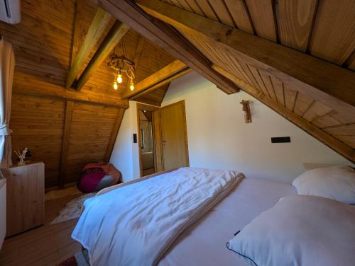 une chambre avec un grand lit dans un grenier dans l'établissement Vila Presjenica, à Bunovci