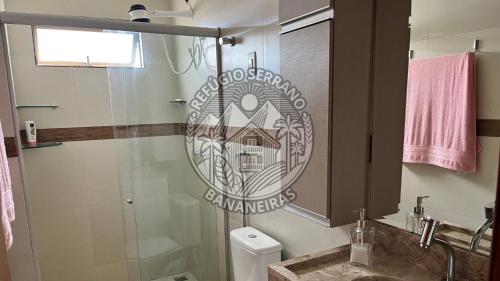 a bathroom with a shower with a sign on the wall at Refúgio Serrano Bananeiras in Bananeiras