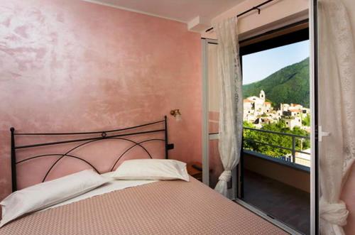 a bedroom with a bed and a window with a view at Albergo Cecchin in Balestrino