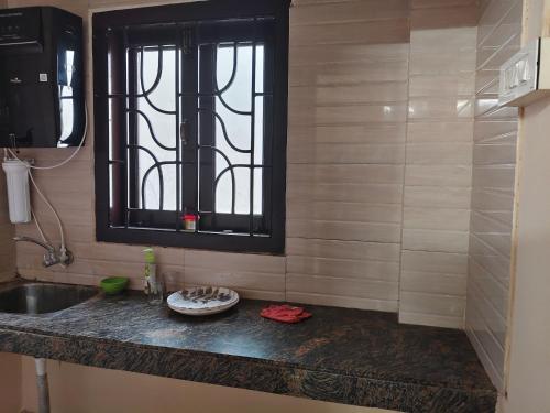 a bathroom with a sink and a window at JM Niwas in Guwahati