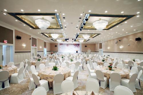 Un salón de banquetes con mesas y sillas blancas. en Lotte Hotel Guam, en Tumon