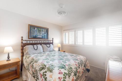 WailuaにあるWailua Bay View 307のベッドルーム1室(ベッド1台、ランプ2つ、窓付)