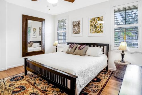 プリンスビルにあるNihilani 25Bの大きなベッドと鏡のある寝室