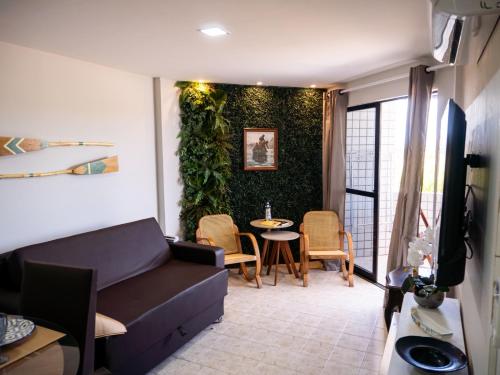 a living room with a couch and a table at Flat Aconchegante em Ponta de Campina in Cabedelo