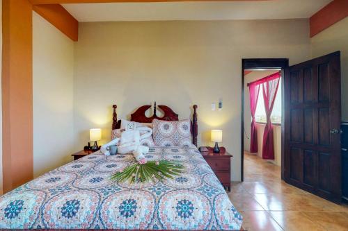 サン・ペドロにあるSouthern #5 at Laguna Suite -Gold Standard Certifiedの花が飾られた大きなベッドのある寝室