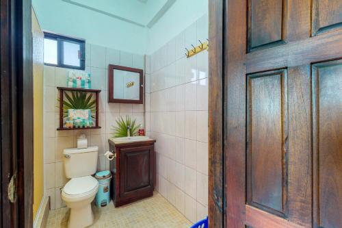 サン・ペドロにあるSouthern #5 at Laguna Suite -Gold Standard Certifiedのバスルーム(トイレ付)、木製のドアが備わります。