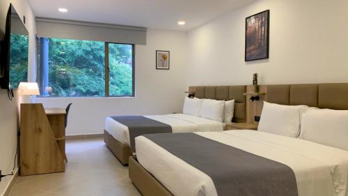 a hotel room with two beds and a window at Hotel Poblado Boutique in Medellín
