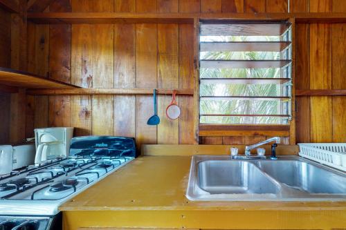 a kitchen with a stove top and a sink at Bonefish at Carol's Cabanas -Gold Standard Certified in Placencia Village