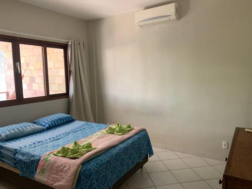 a bedroom with a bed with two green leaves on it at Apto em Condomínio Brisas do Amor in Pipa