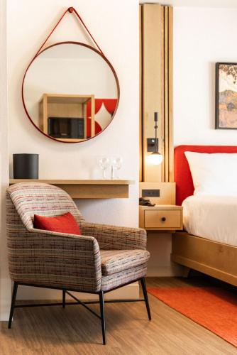 a bedroom with a mirror and a chair and a bed at El Bonita Motel in St. Helena