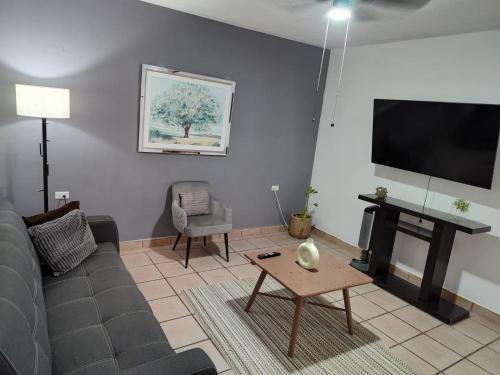 een woonkamer met een bank en een flatscreen-tv bij Casa Ragma in Parras de la Fuente