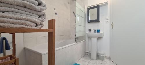 een badkamer met een wastafel, een bad en een toilet bij Jolie maison de location avec terrasse couverte et parking privé in Douarnenez
