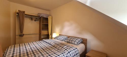 een slaapkamer met een bed met twee kussens erop bij Jolie maison de location avec terrasse couverte et parking privé in Douarnenez