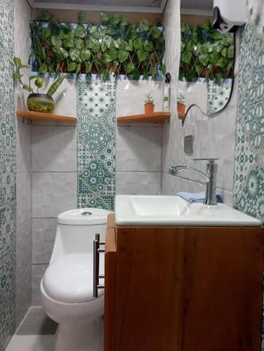 a bathroom with a sink and a toilet and a mirror at Cabaña El Jericoano in Jericó