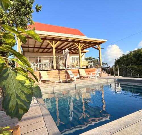 a house with a swimming pool in front of a house at Villa Mamina Martinique in Fort-de-France