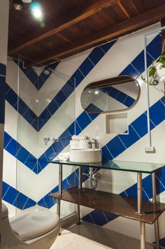 a bathroom with a blue and white tiled wall at Hotel PIA Colombia in Marinilla