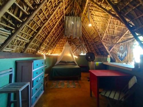 a bedroom with a bed and a desk in a room at El Chiringuito, Mermejita in Mazunte