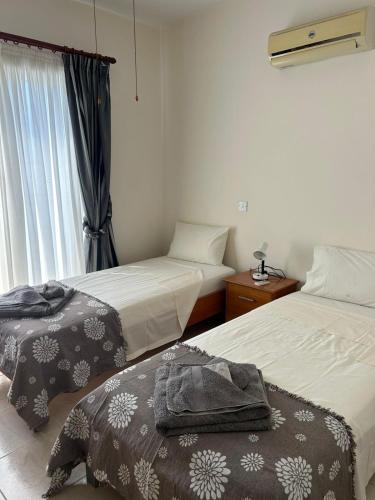 ein Hotelzimmer mit zwei Betten und einem Fenster in der Unterkunft Venus205 in Paphos City