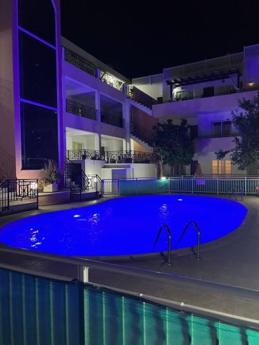 Una gran piscina azul frente a un edificio en Venus205, en Pafos