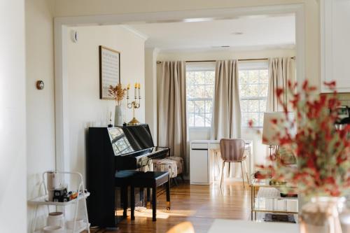 a living room with a piano and a table at Urban Downtown Stamford Home 45 min to NYC with Garage And Yard in Stamford