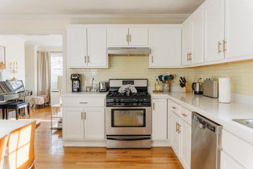a kitchen with white cabinets and a stove at Urban Downtown Stamford Home 45 min to NYC with Garage And Yard in Stamford