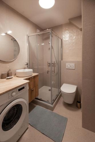 a bathroom with a shower toilet and a washing machine at Studio Cosy - Bas Montreuil in Montreuil