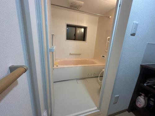 un baño con bañera y lavabo en Suzuya, en Hanabuchihama