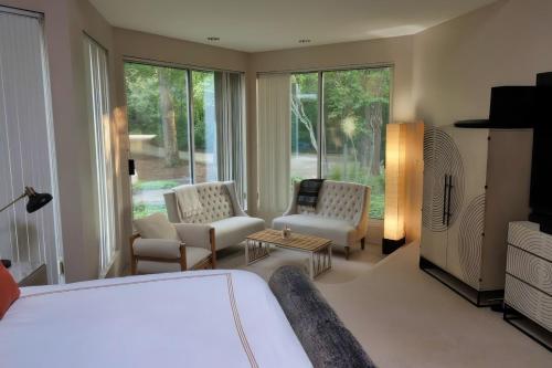 een slaapkamer met een bed en twee stoelen en een televisie bij Stunning house - cozy & elegant in Bannockburn