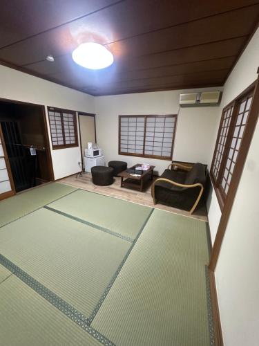 una sala de estar con un sofá y una mesa en Suzuya, en Hanabuchihama