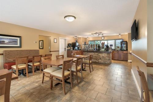 Un comedor con mesas y sillas y una cocina. en Best Western Sicamous Inn, en Sicamous